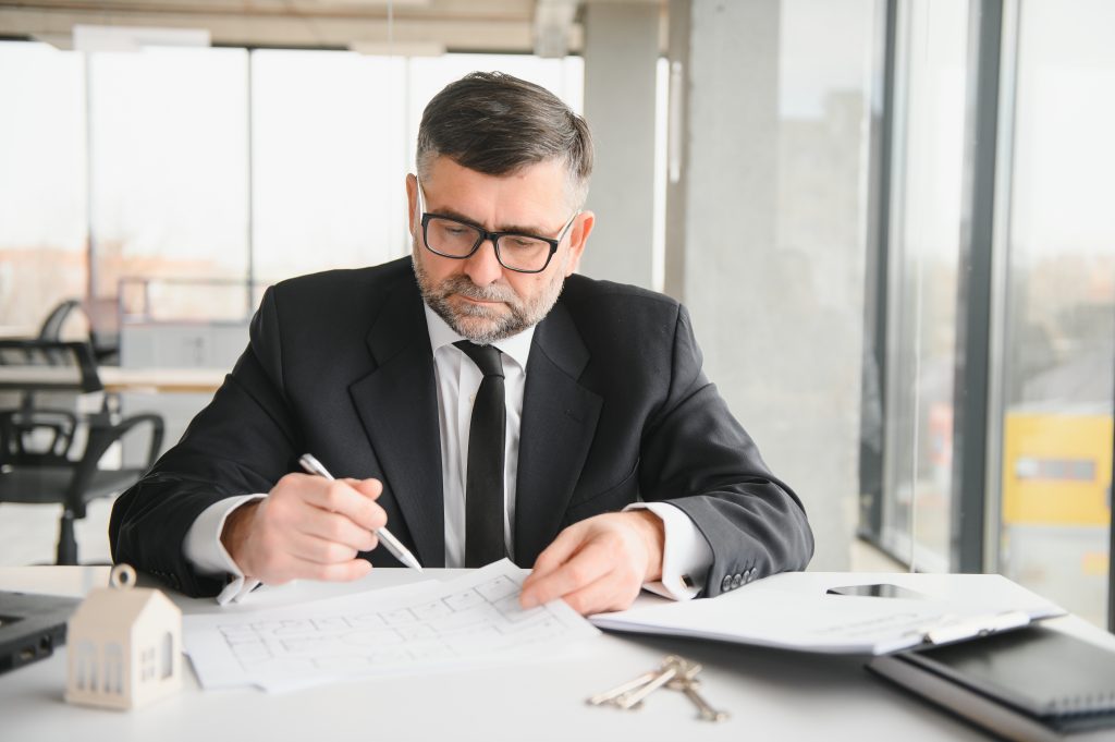 realtor in suit sitting at desk in office realtor is showing apartment photo
