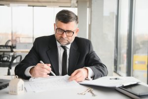 realtor in suit sitting at desk in office realtor is showing apartment photo